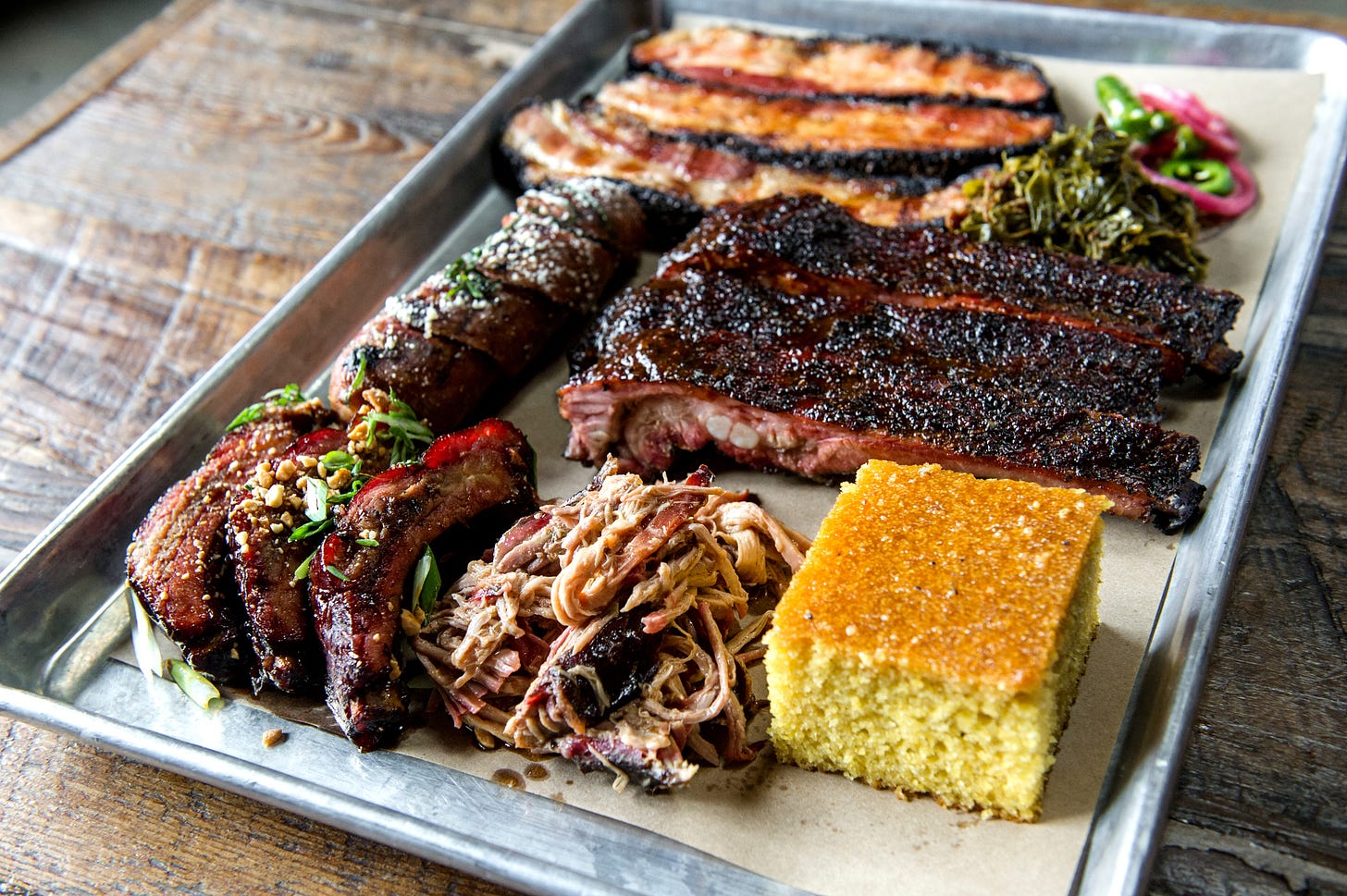 Tray of brisket, pulled pork, ribs, slab bacon and cornbread