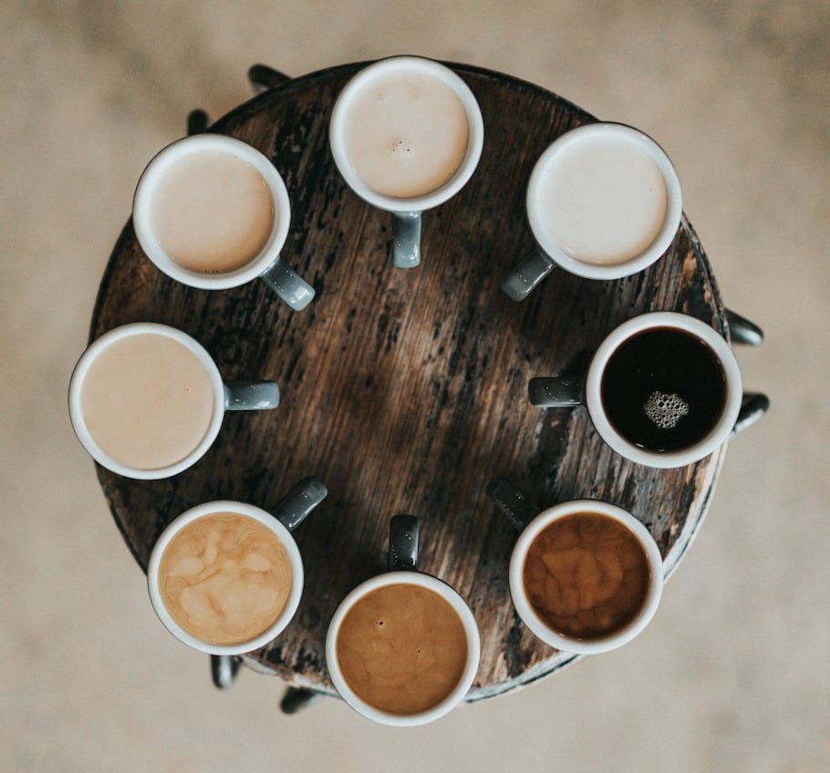 flat lay photography of eight coffee latte in mugs on round table