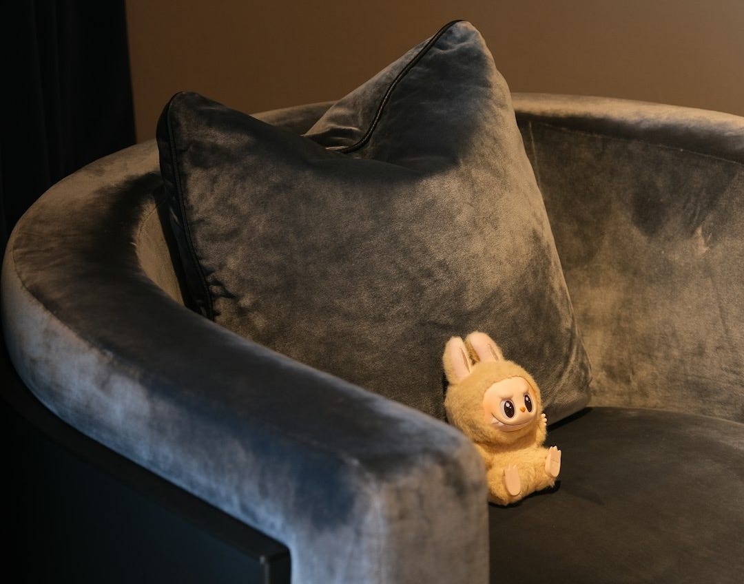 A stuffed bunny sits on a luxurious gray couch. A stuffed bunny sits on a luxurious gray couch.