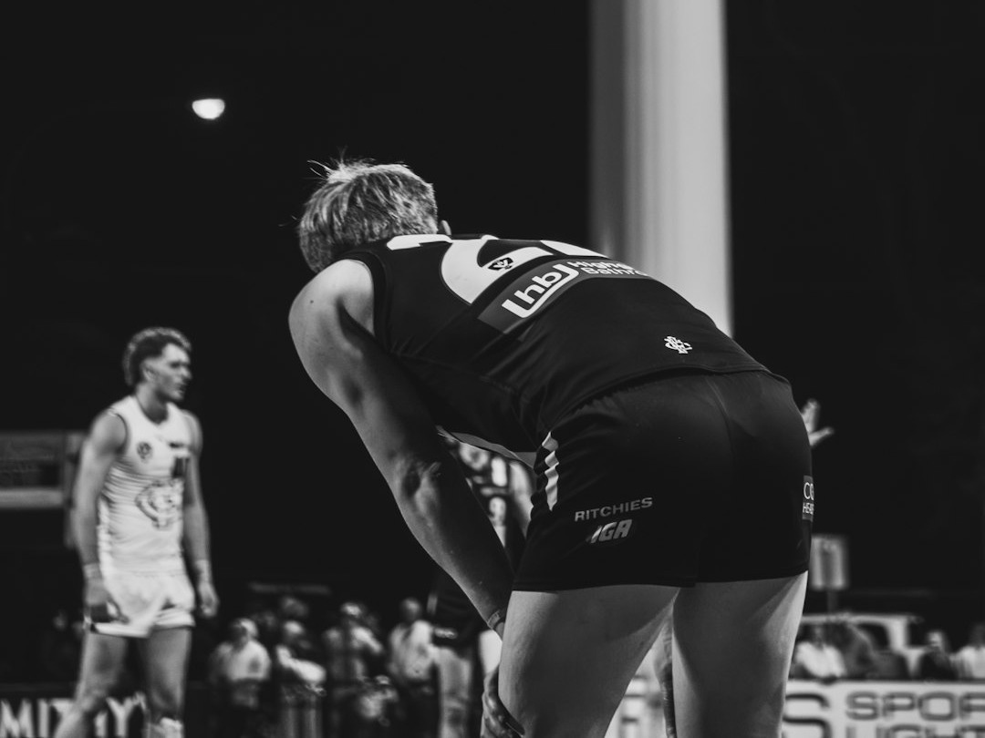 Player bent over on a sports field at night.