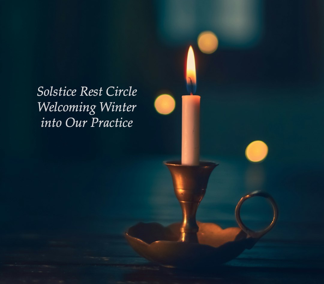 white candle lit on brass candle holder