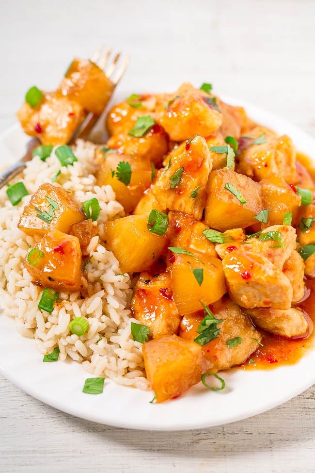 Slow Cooker Hawaiian Chicken with Pineapple atop bed of white rice on plate with fork. 