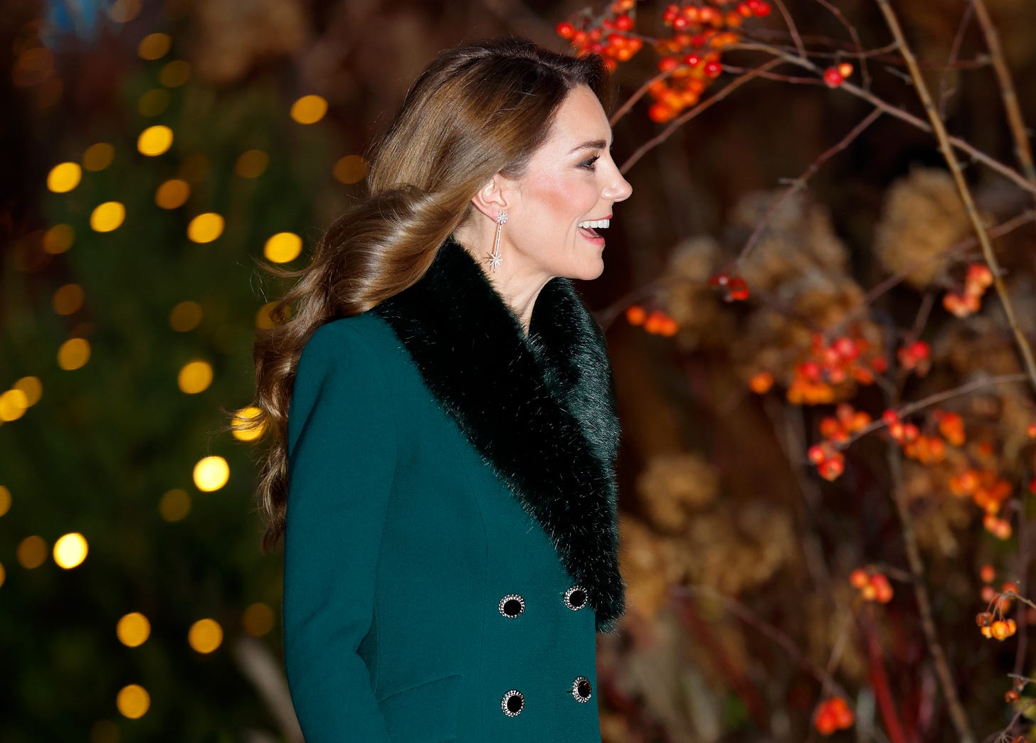 Princess Kate smiling wearing a green coat with festive lights in the background Princess Kate smiling wearing a green coat with festive lights in the background