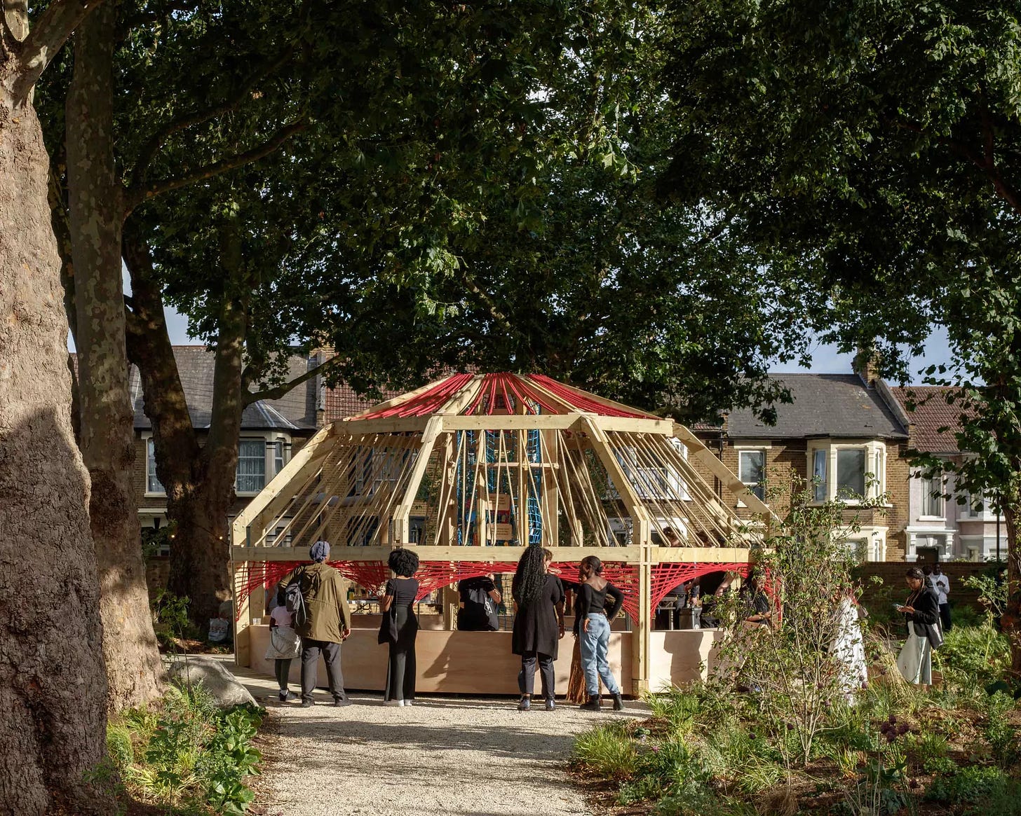 Image: People’s Pavilion 2023 by 18-year olds Bruno De Marco, Tomi Balogun and Zhané Philips named ‘Roots of Heritage’ and made using locally-sourced timber, then temporarily exhibited in the Lea Bridge Library garden (Waltham Forest) [Credit: Luke O’Donovan].