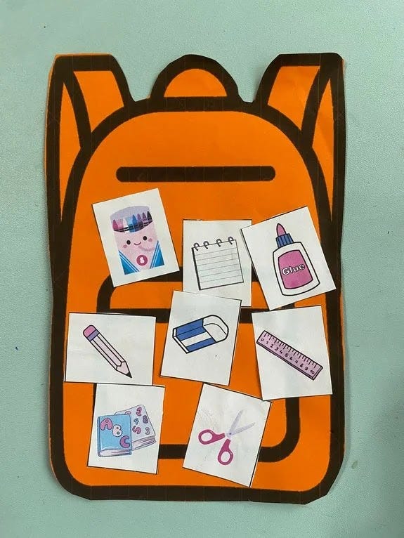 Cut out of a school bag from a cardboard with stickers of materials used in school activities