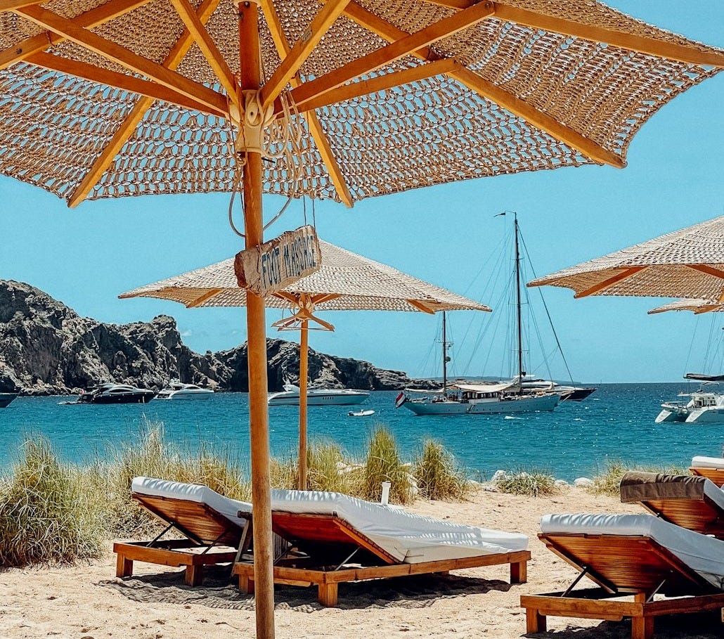 brown wooden beach lounge chairs on beach during daytime