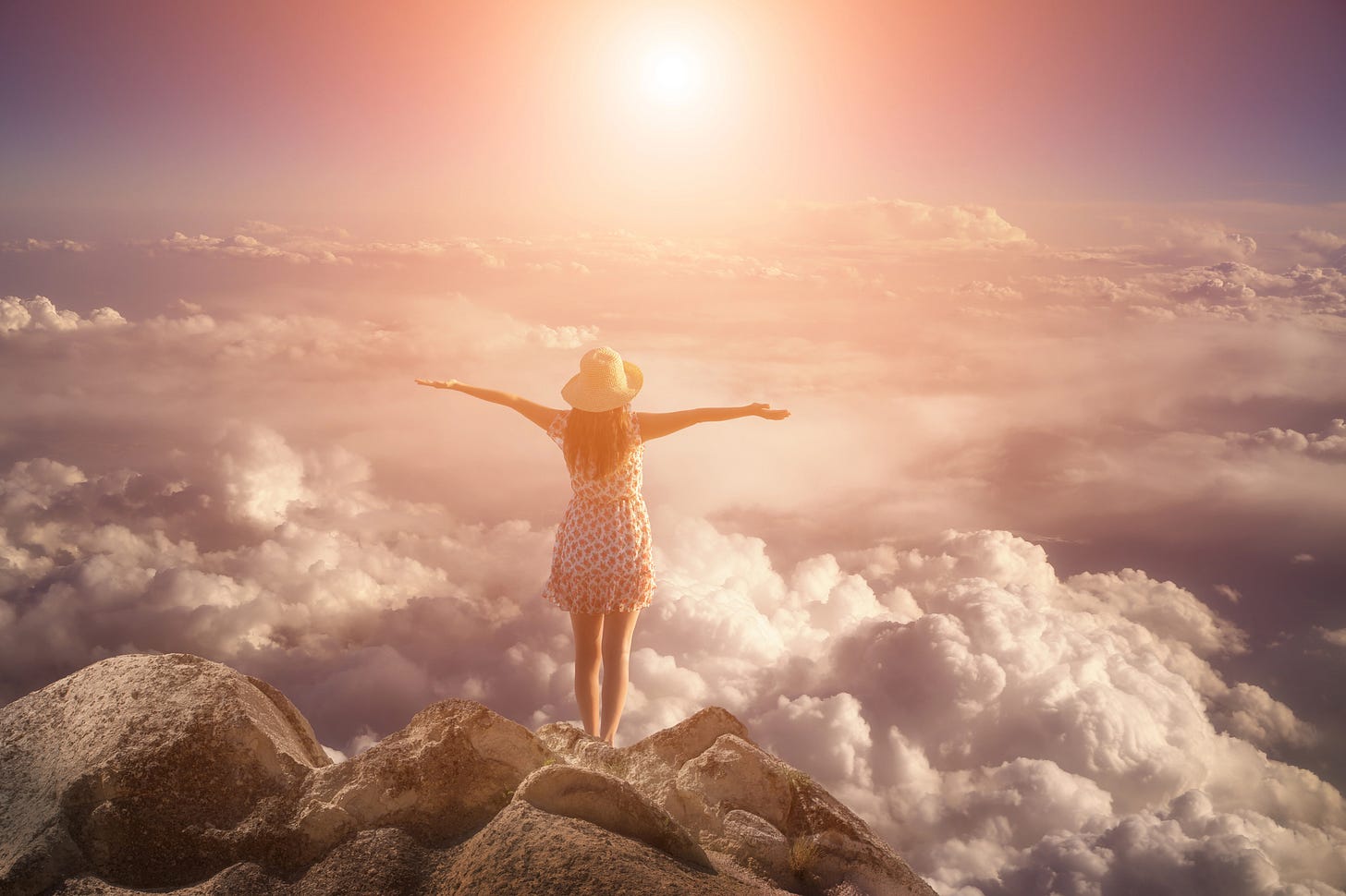 menina em um penhasco de braços abertos vendo as nuvens e o sol se pondo. uma visão extasiante.