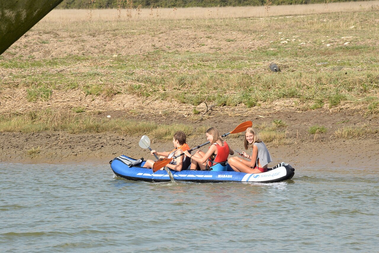 Avec un canoë gonflable, trois adolescents en promenade sur la Seudre au niveau des Flottes (commune de l’Éguille). L’Éguille-sur-Seudre, Charente-Maritime, France