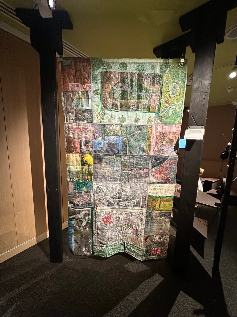 A colourful quilt that has been hand made incorporating detailed maps, designs, and patterns. A colourful quilt that has been hand made incorporating detailed maps, designs, and patterns.