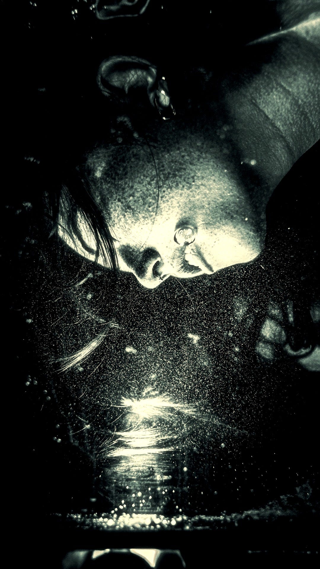 Person submerged underwater with bubbles and light reflections. Person submerged underwater with bubbles and light reflections.