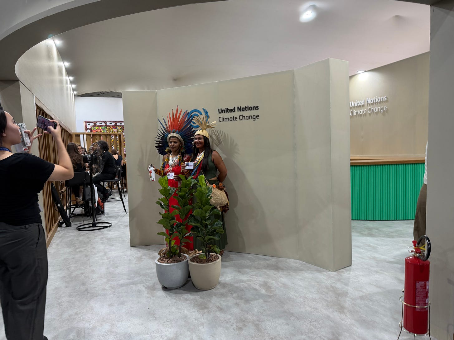 Two people pose for a photo at COP30 in Belém, Brasil.