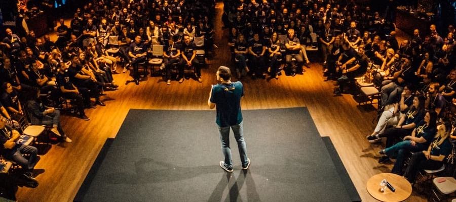 Speaker on stage in front of audience Speaker on stage in front of audience