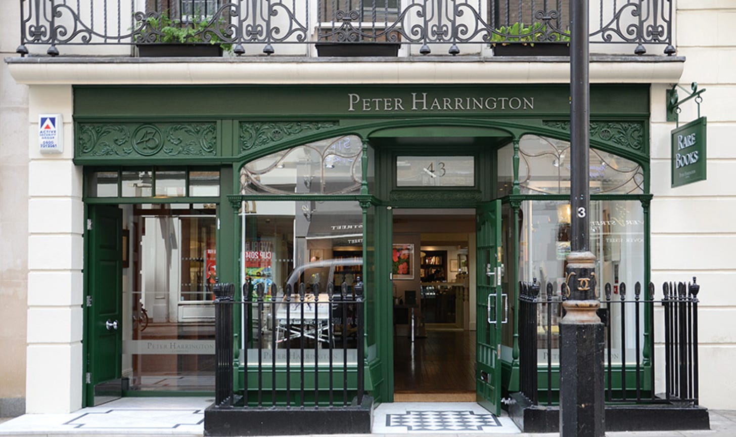 Storefront of Peter Harrington Rare Books at 43 Dover Street in Mayfair, London, the city's leading antiquarian and rare book dealer. The shop features a polished dark green Edwardian shopfront with ornate Art Nouveau ironwork, gold lettering reading "PETER HARRINGTON," the number 43, and a hanging green "RARE BOOKS" sign, framed by black wrought-iron railings and a cream stone facade. Storefront of Peter Harrington Rare Books at 43 Dover Street in Mayfair, London, the city's leading antiquarian and rare book dealer. The shop features a polished dark green Edwardian shopfront with ornate Art Nouveau ironwork, gold lettering reading "PETER HARRINGTON," the number 43, and a hanging green "RARE BOOKS" sign, framed by black wrought-iron railings and a cream stone facade.