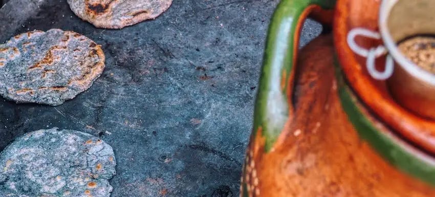 Blue corn tortillas on a cast iron comal