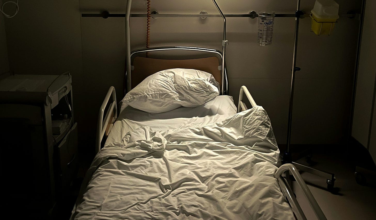 a hospital room with a bed and a monitor a hospital room with a bed and a monitor