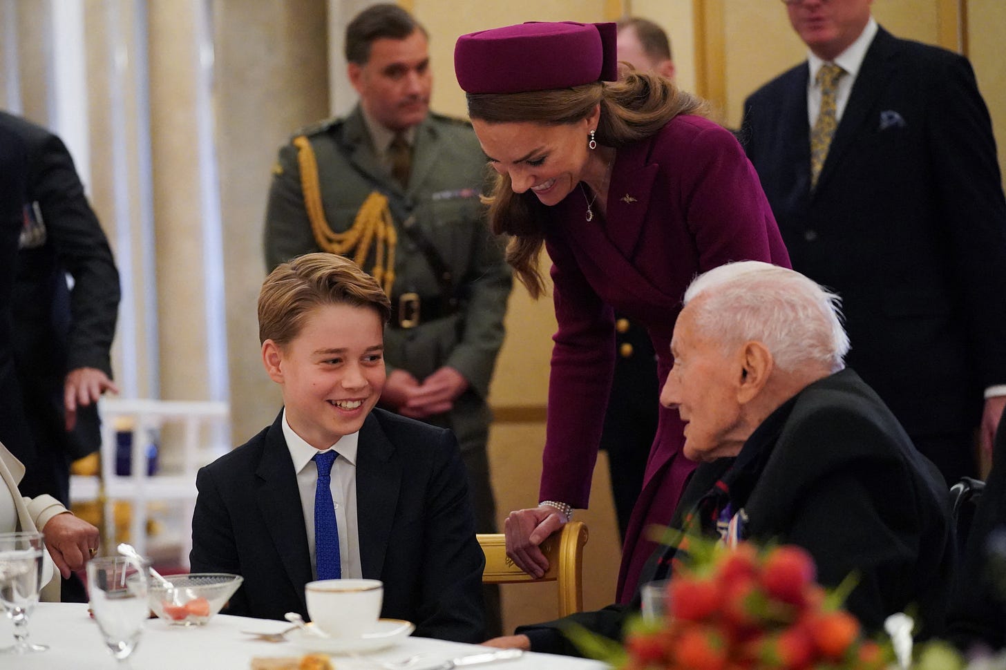 Prince George laughing with a veteran with Princess Catherine behind Prince George laughing with a veteran with Princess Catherine behind