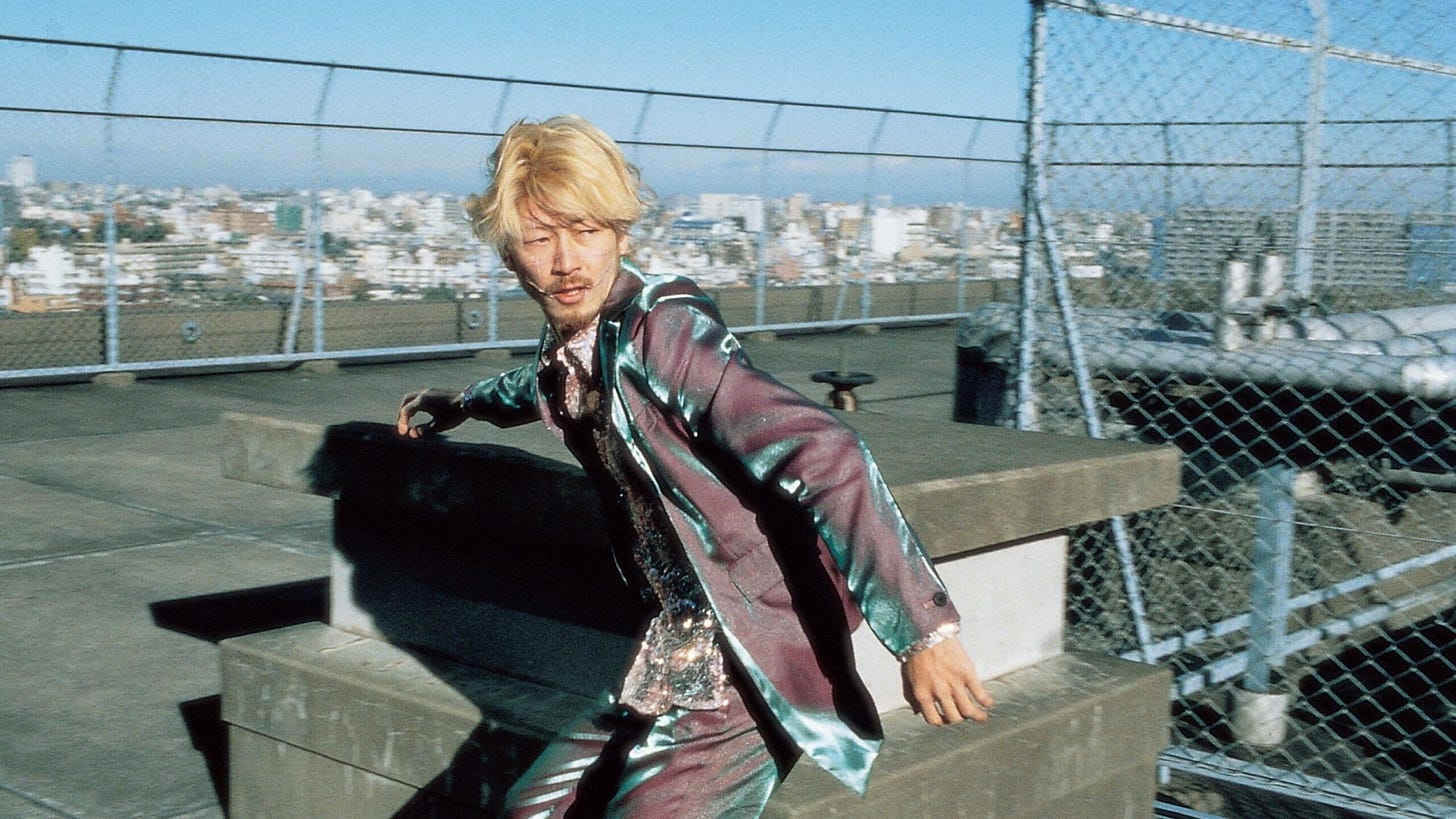 A bleached blond Tadanobu Asano traverses a rooftop in "Ichi The Killer" (2001)