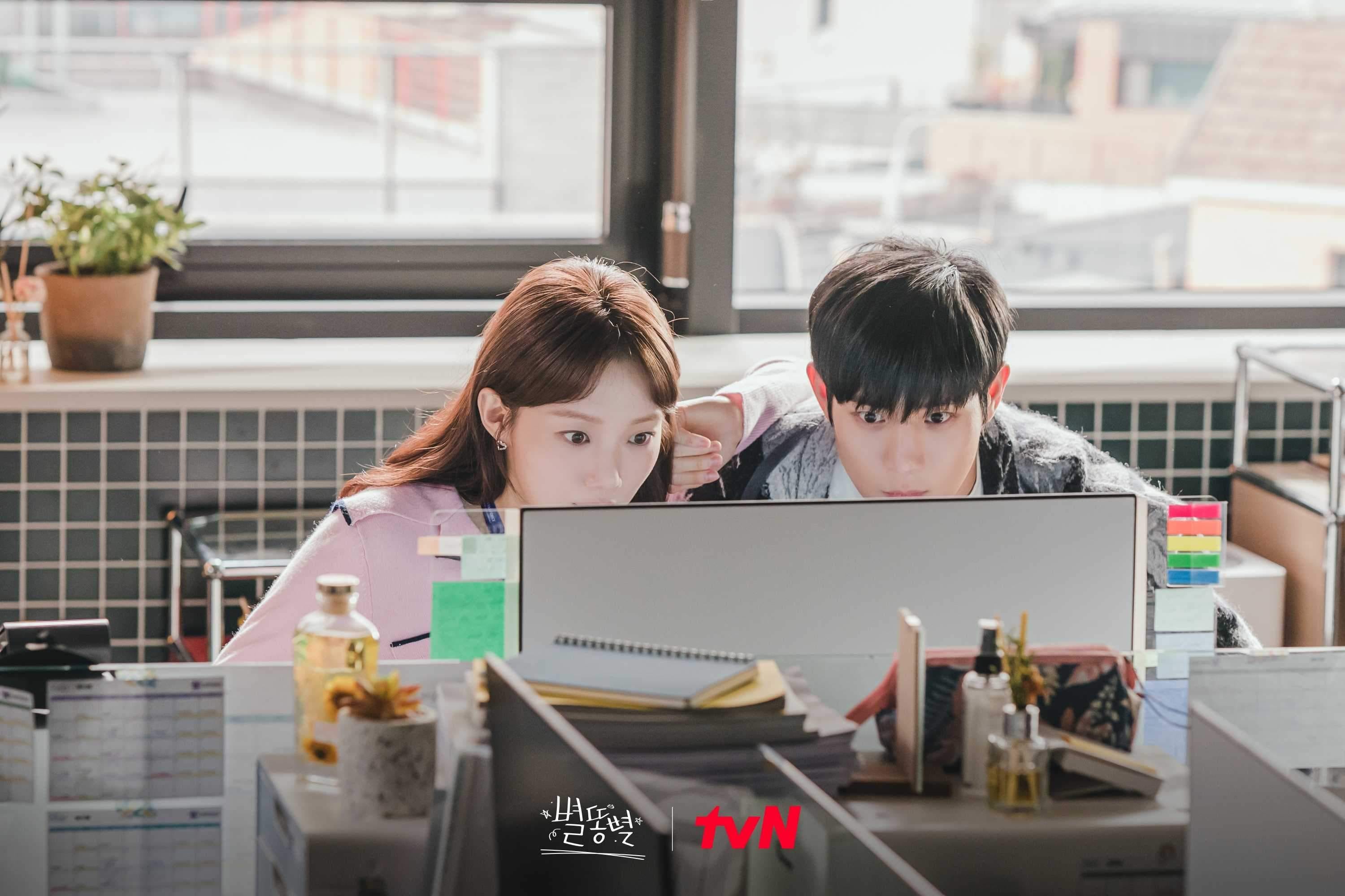 A man and a woman sit closely together as they look at a desktop computer screen A man and a woman sit closely together as they look at a desktop computer screen