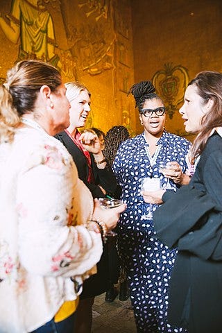 in-person meeting participants casually talking while standing with drinks