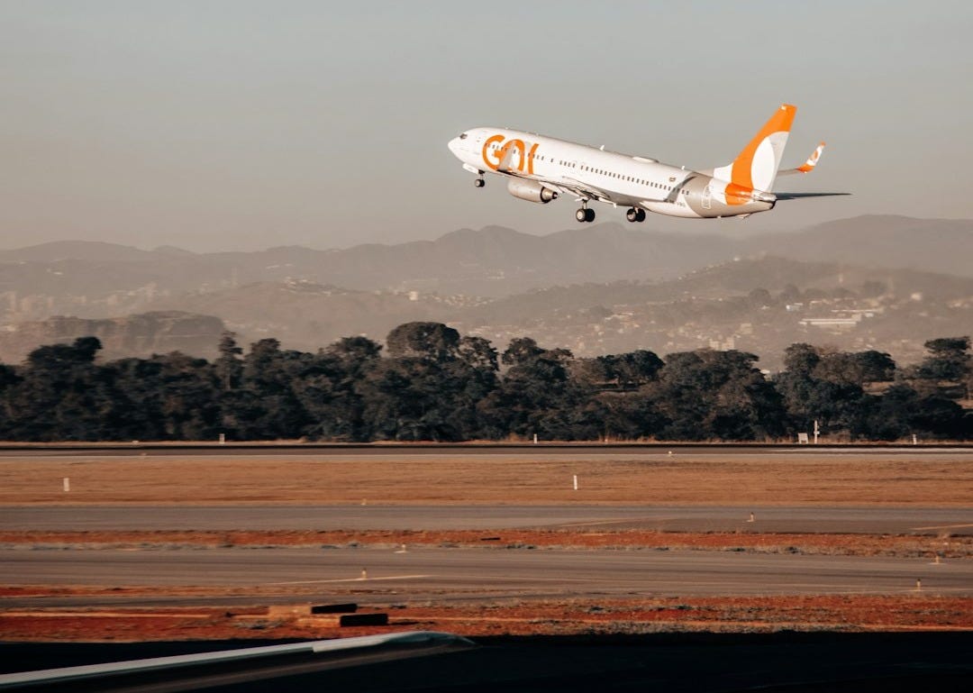 white and orange airplane in mid air during daytime