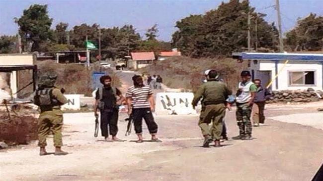 The undated photo obtained by Press TV shows Israeli soldiers speaking face-to-face with foreign-backed militants near the Israeli occupied Golan heights in Syria.