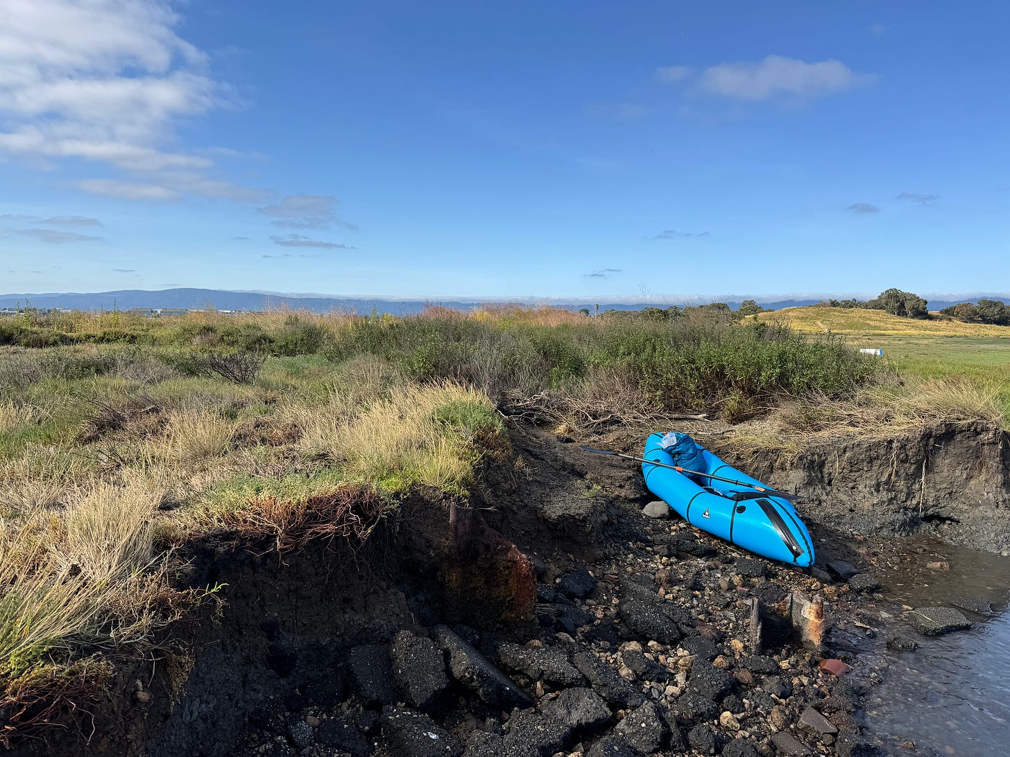Blue packraft on Anthropocene jetty of SF Bay coast