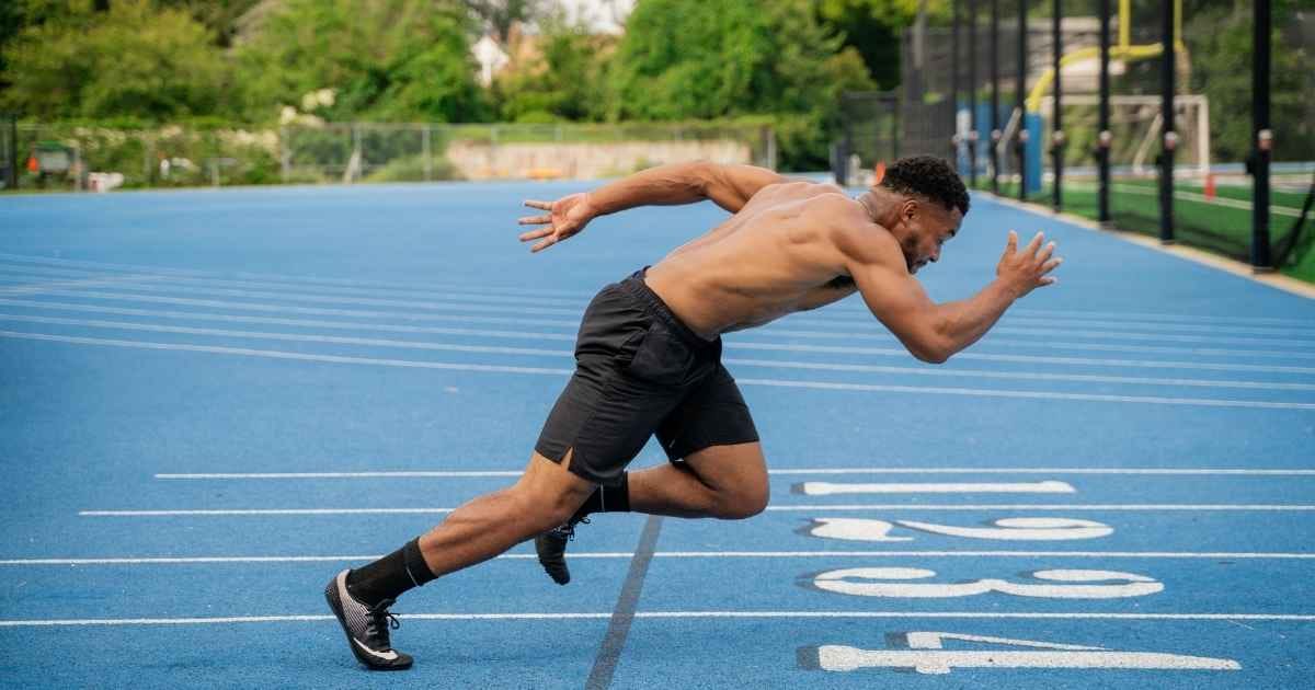 A man running on a track with a blue background A man running on a track with a blue background
