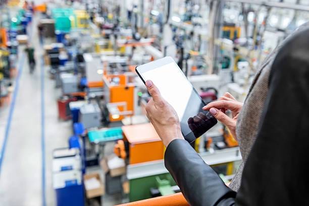 Orders in factory Horizontal color image of businesswoman - unrecognizable person - working with digital tablet in large futuristic factory. Woman standing on top of a balcony, holding touchpad and checking inventory of a manufacturing company on touchscreen tablet. Focus on businesswoman's hands holding black tablet, futuristic machines with incidental person in background. product manufacturing stock pictures, royalty-free photos & images Orders in factory Horizontal color image of businesswoman - unrecognizable person - working with digital tablet in large futuristic factory. Woman standing on top of a balcony, holding touchpad and checking inventory of a manufacturing company on touchscreen tablet. Focus on businesswoman's hands holding black tablet, futuristic machines with incidental person in background. product manufacturing stock pictures, royalty-free photos & images
