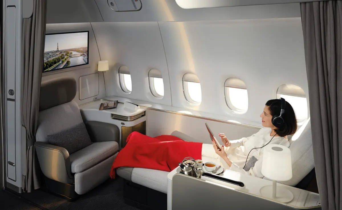Photo of a women reclining in an extended First Class bed-seat in Air France's La Première class.