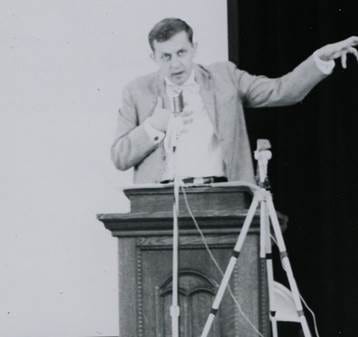 A person speaking into a microphone

AI-generated content may be incorrect.