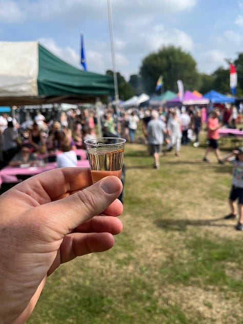 First image is of a hand holding a sample of drink, the second is of a man wearing a yellow and white striped apron at a food festival and the third shows a hand holding a sample of food with a Ukrainian flag in the background.