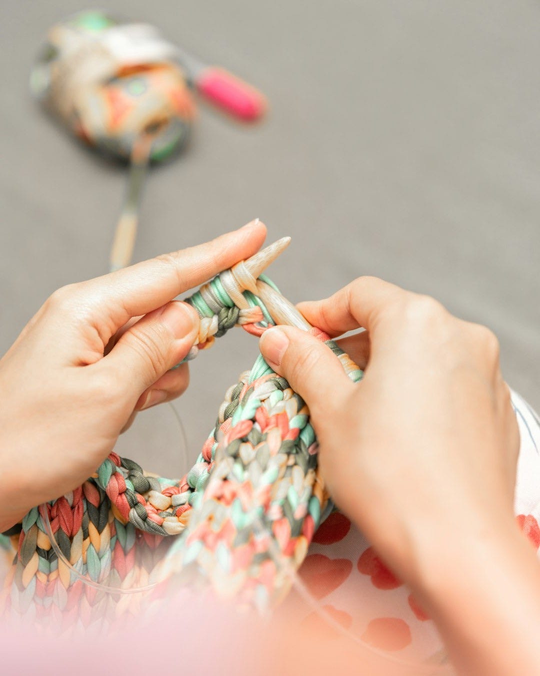 a woman is knitting a piece of fabric