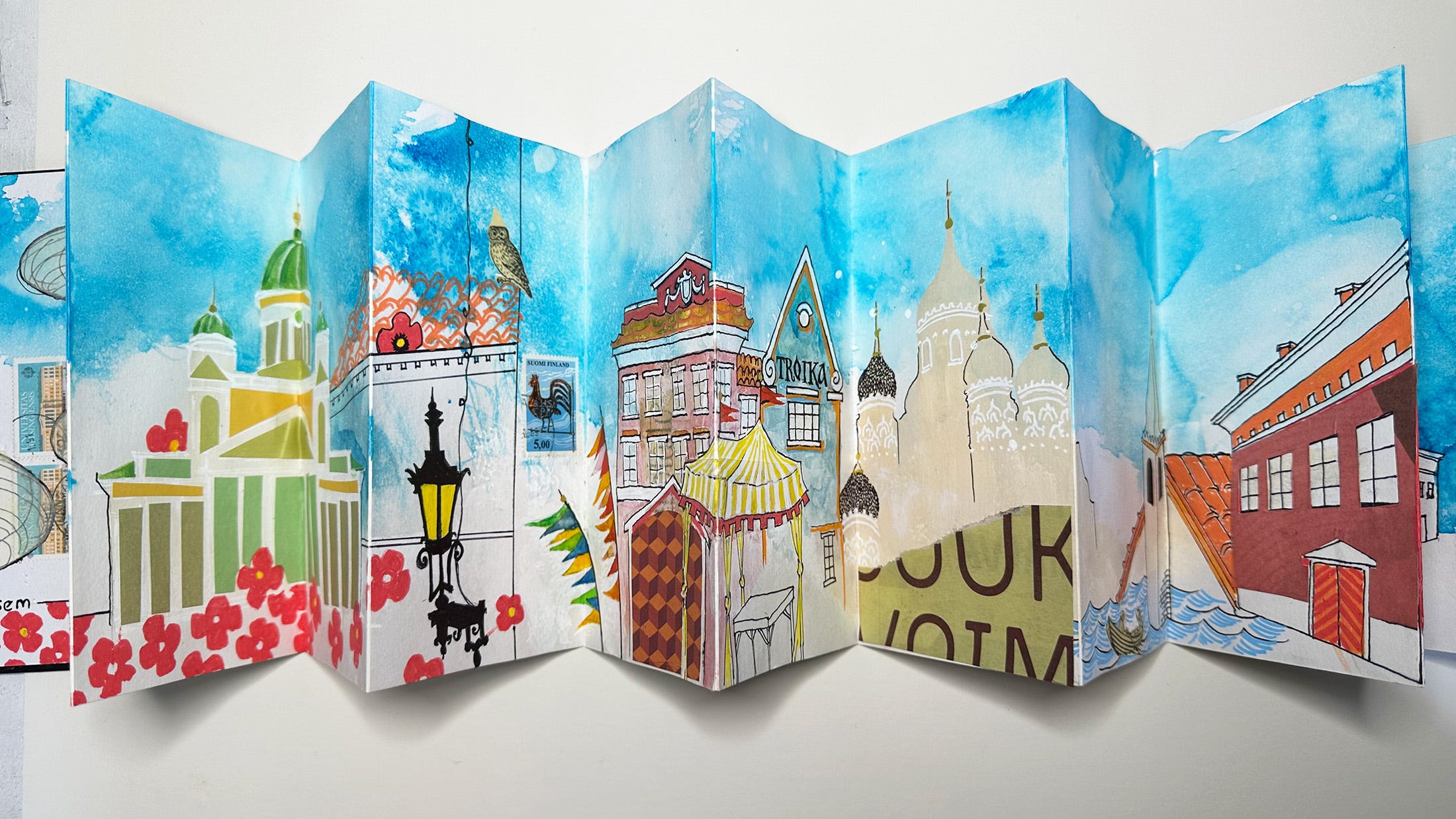 photo of a concertina sketchbook with colorful interpretations of buildings in Helsinki and Tallin