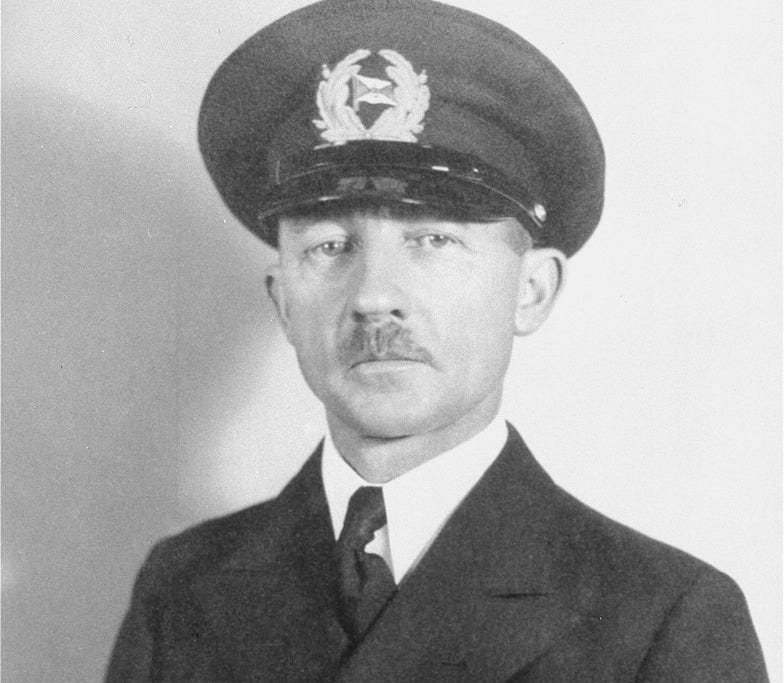 Portrait of a man with light skin tone and a full mustache wearing a full dress naval uniform.