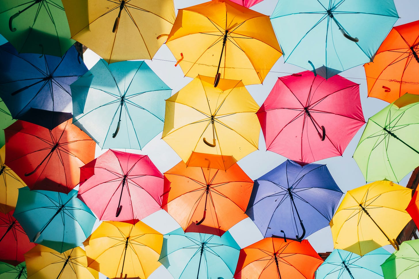 A canopy of bright umbrellas in all the colors of the rainbow.