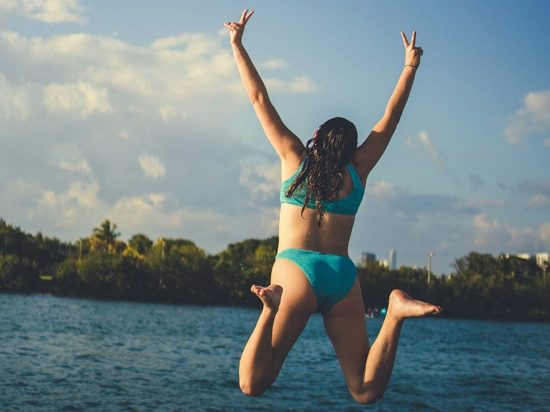 a woman in a bikini jumping into the air a woman in a bikini jumping into the air