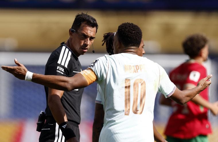 Mbappé le protesta a Tello por la demora en el penal.