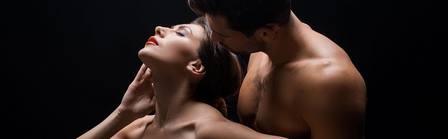 Woman eyes closed with man kissing her on dark background