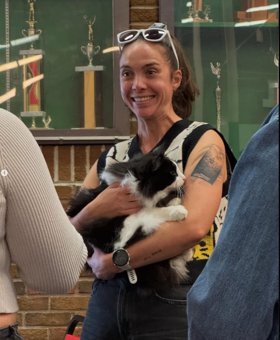 An image of me holding a black and white cat in my arms with a stupid grin on my face.