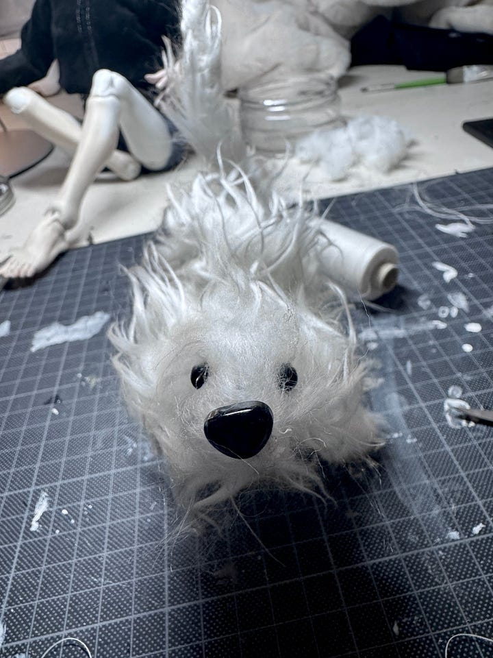 A fluffy white stop motion dog in the making and with a black background