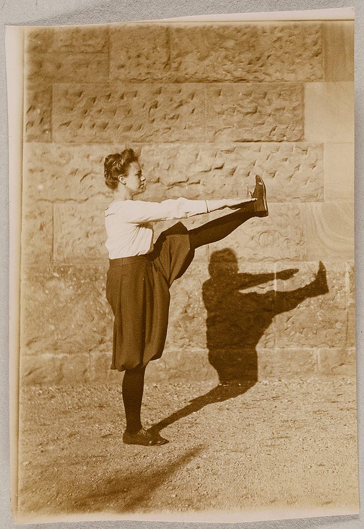 Woman standing on right leg with lift leg extended reaching for her foot