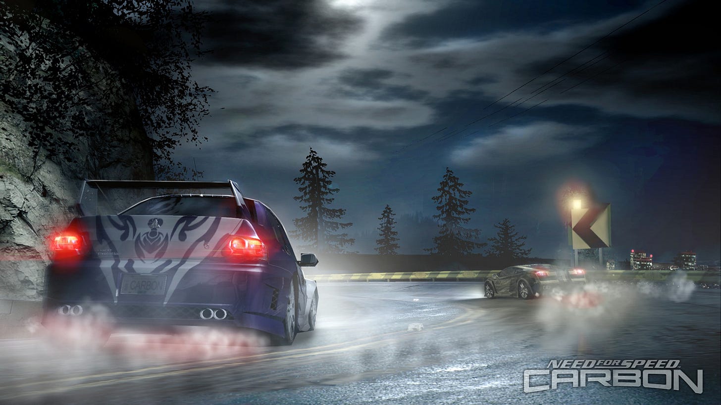 A wallpaper from Need For Speed Carbon. Two cars are racing down a bend in a canyon at night, passing in front of the camera. The city glimmers in the background.