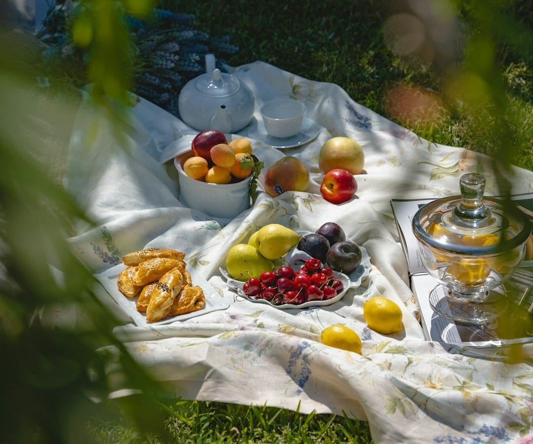 a picnic is set out on a blanket in the grass