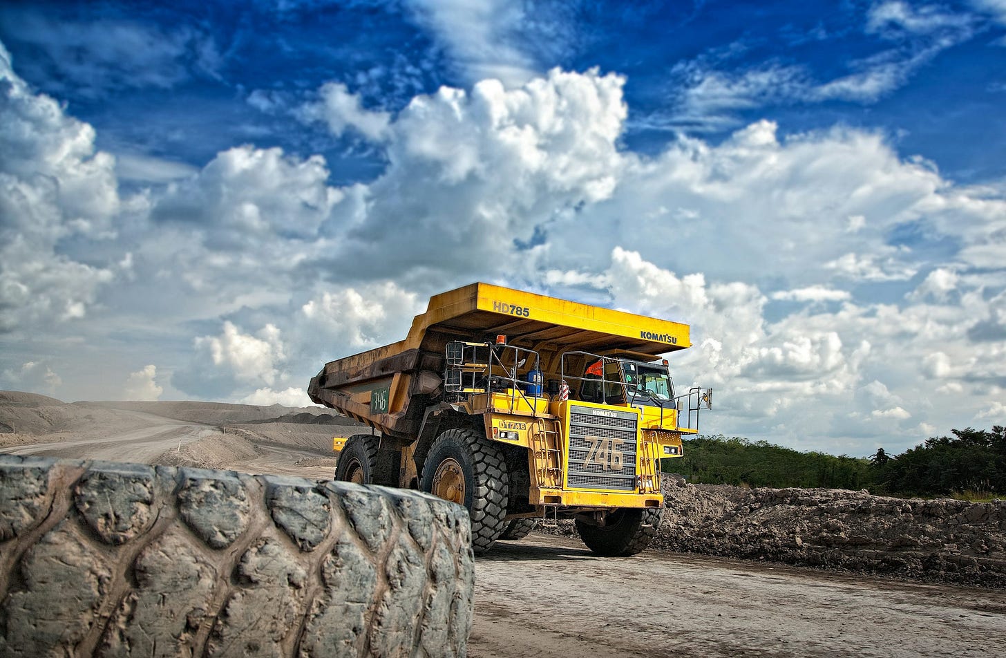 yellow truck on gray road during daytime