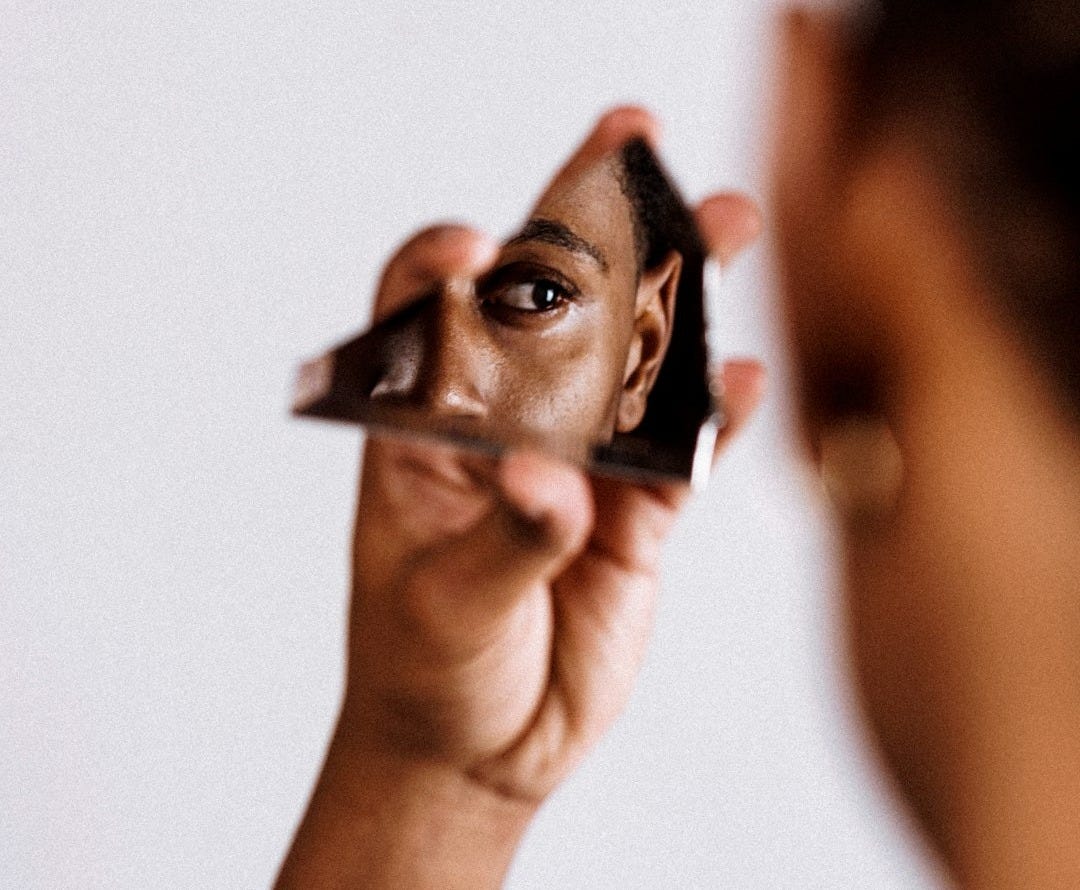 man holding broken mirror