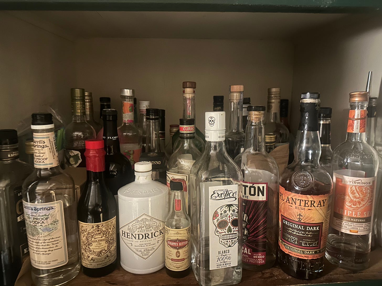 photo of a shelf full of bottles of spirits of many varieties photo of a shelf full of bottles of spirits of many varieties