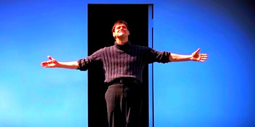 Jim Carrey as Truman Burbank standing in front of the exit door to his reality series in The Truman Show's ending.
