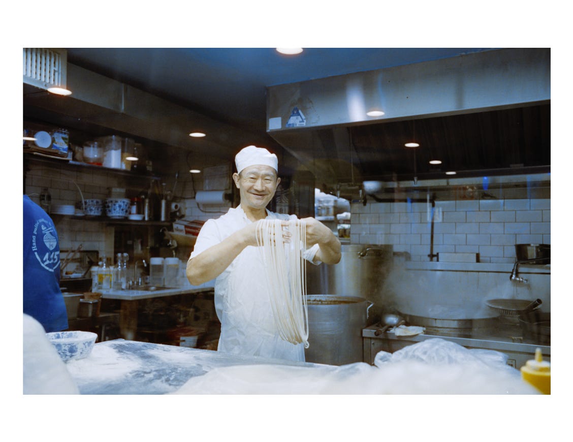 A chef holding hand-pulled ramen. A chef holding hand-pulled ramen.