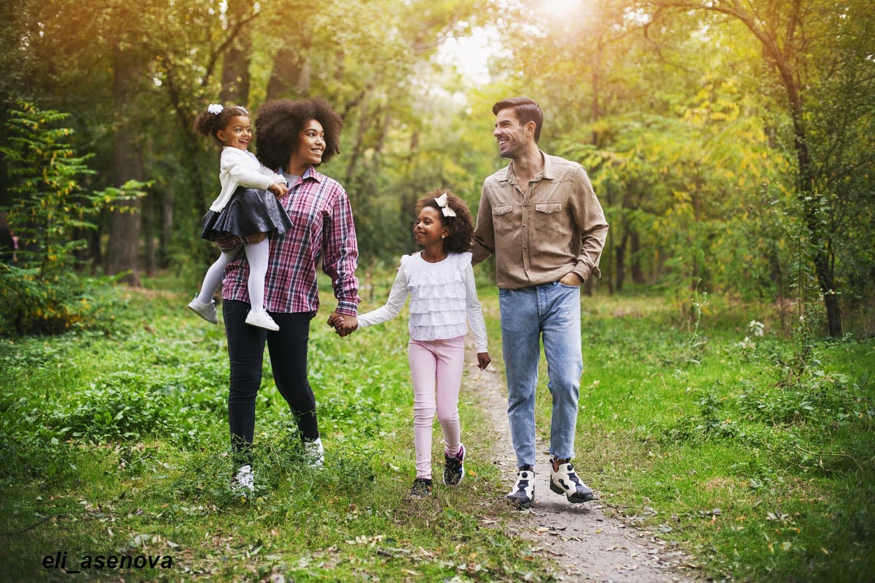 Happy family walking along a path in the woods Happy family walking along a path in the woods