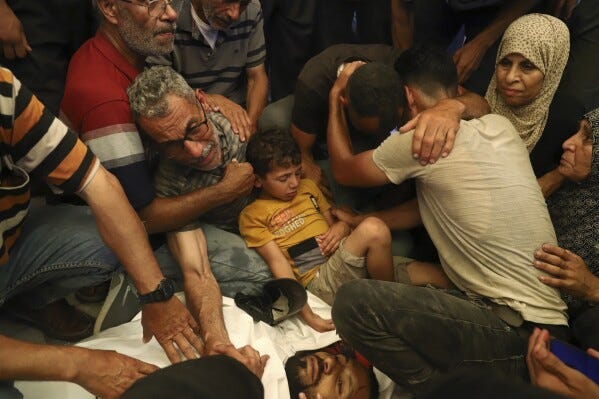 Ata Qasas, center left, mourns over the body of his son Rashad Qasas, who was killed while heading to an aid distribution hub, during his funeral in Rafah, southern Gaza Strip, Wednesday, June 11, 2025. (AP Photo/Mariam Dagga, File)